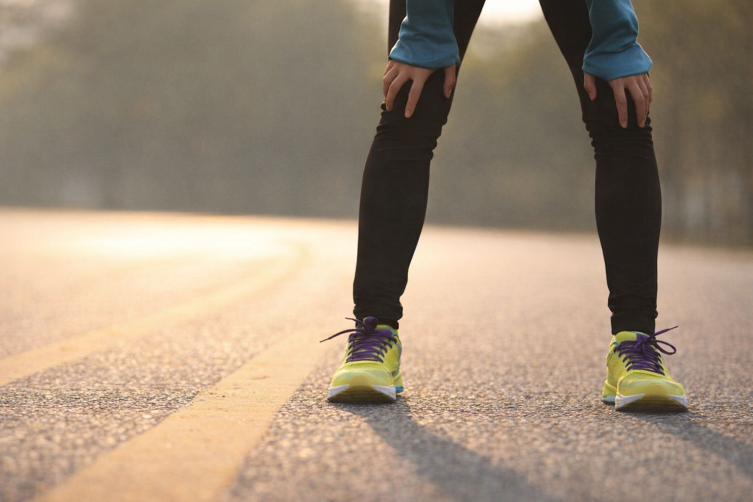 Löpare vilar på vägen i solnedgången efter träning.